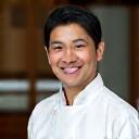 Portrett av kokk Kenji Tanaka, en japansk sushimester med et varmt smil.
